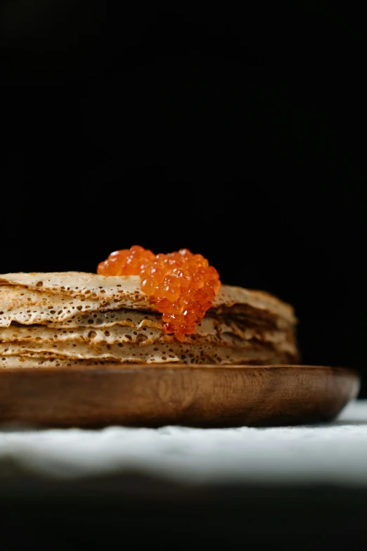 a stack of pancakes sitting on top of a wooden plate, by Julia Pishtar, pexels contest winner, an island made of red caviar, angelina stroganova, marmalade, folded