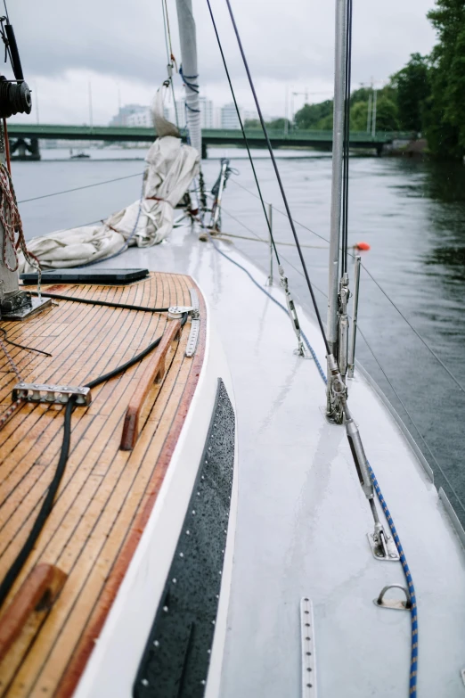 a boat on a body of water with a bridge in the background, a portrait, unsplash, modernism, on the deck of a sailing ship, in a rainy environment, low detail, thin straight lines
