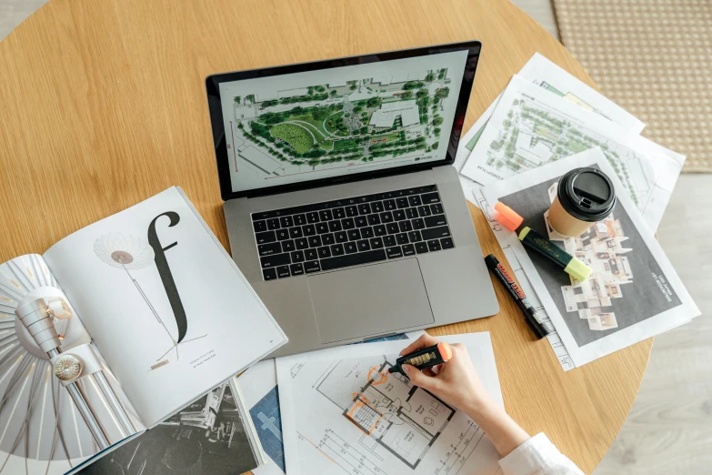 a laptop computer sitting on top of a wooden table, a computer rendering, pexels, architectural plan, green architecture, casually dressed, an intricate