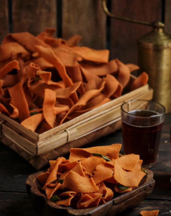 a wooden tray filled with chips next to a glass of beer, a still life, by Basuki Abdullah, trending on pexels, hurufiyya, orange ribbons, terracotta, triangle shards, trap made of leaves