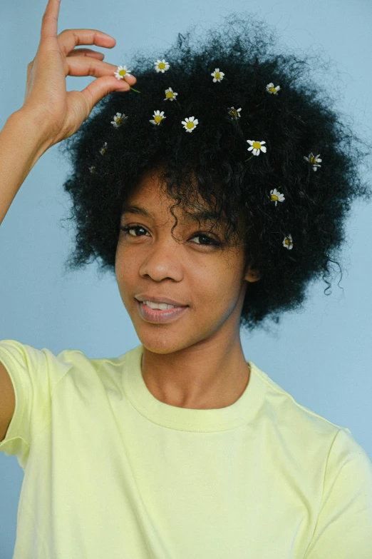 a woman with a bunch of flowers in her hair, by Lily Delissa Joseph, trending on unsplash, short black curly hair, chamomile, official product photo, modeled