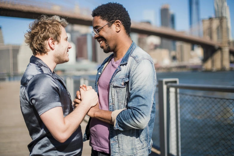 two men standing next to each other in front of a bridge, pexels, gay rights, playful smirk, fist fight, alana fletcher