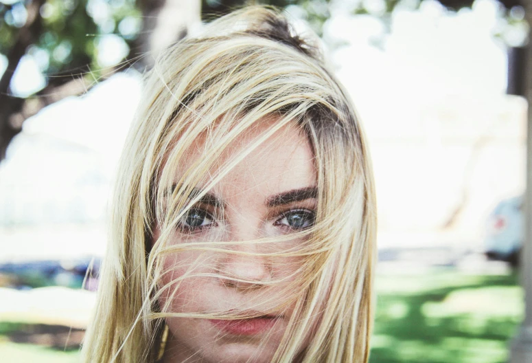 a woman with blonde hair blowing in the wind, inspired by Elsa Bleda, pexels contest winner, photorealism, straight eyebrows, lilly collins, heterochromia, rectangle