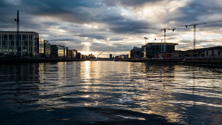 a body of water under a cloudy sky, by Tom Wänerstrand, pexels contest winner, hurufiyya, sun and shadow over a city, irish, construction, thumbnail