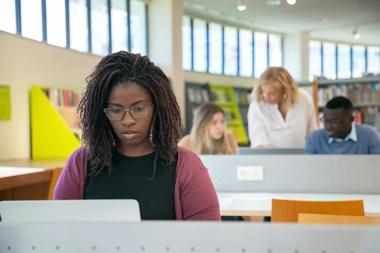 a woman working on a laptop in a library, by Carey Morris, pexels contest winner, academic art, photo of a black woman, 2 5 6 x 2 5 6 pixels, slight overcast lighting, group photo