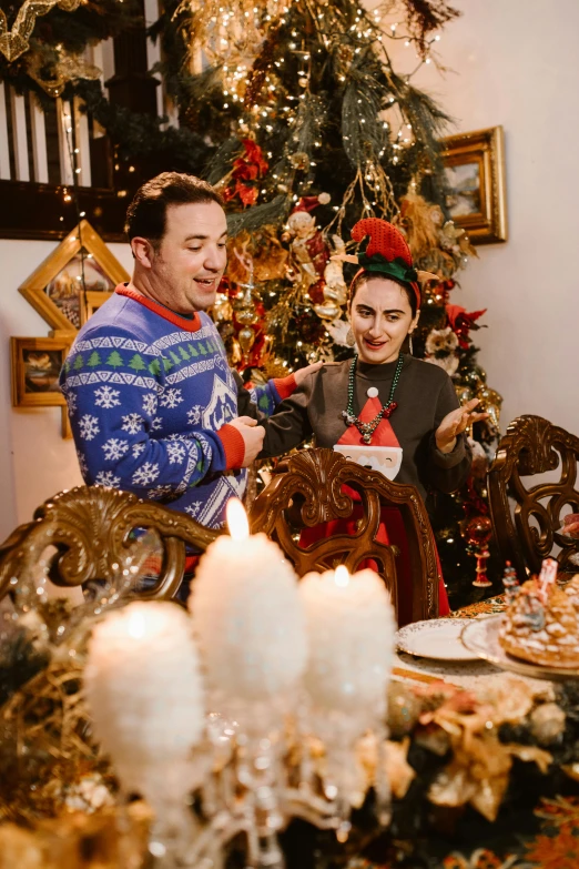 a man and woman sitting at a table in front of a christmas tree, lots of decoration and furniture, profile image, elves, home alone