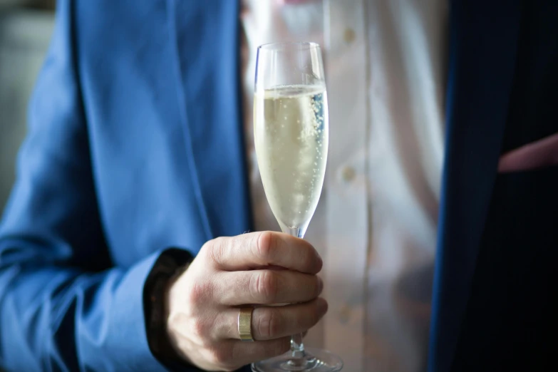 a man in a blue suit holding a glass of champagne, by Alice Mason, pexels contest winner, private press, detailed white, rectangle, premium quality, large tall