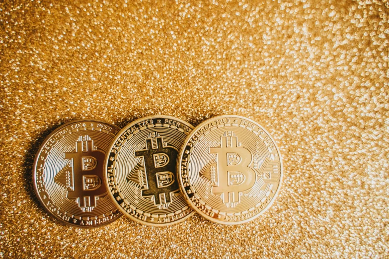 three bitcoins on a gold background, by Lena Alexander, sequins, background image, 🦩🪐🐞👩🏻🦳, 2019 trending photo