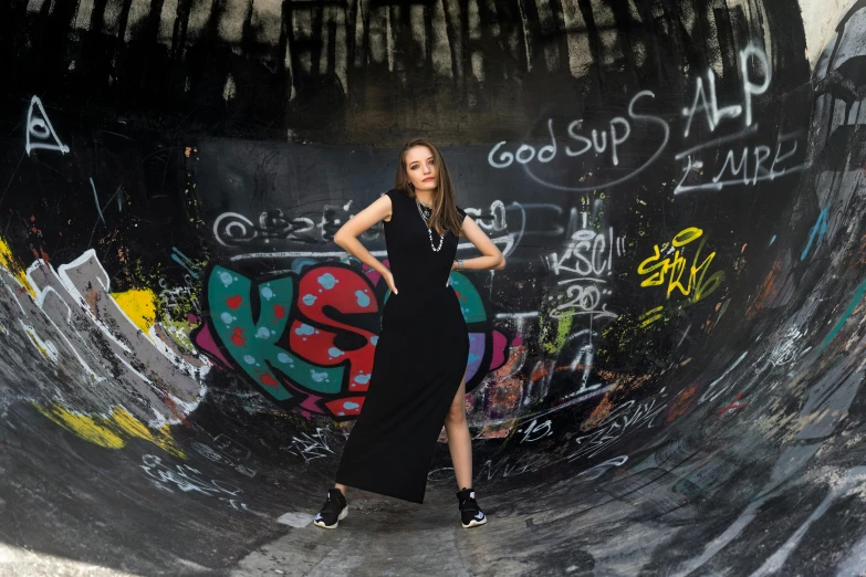 a woman standing in the middle of a skateboard ramp, pexels contest winner, graffiti, dark black long dress, stood in a tunnel, full frame image, modelling
