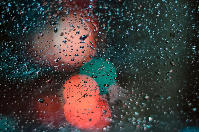 a close up of a window with raindrops on it, an album cover, inspired by Elsa Bleda, pexels contest winner, orange and teal color, translucent orbs, red and green lighting, water particules