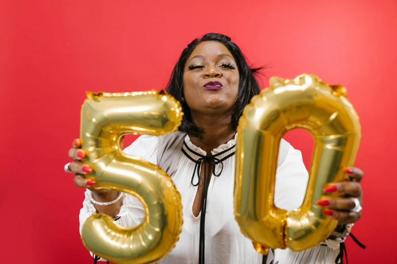 a woman holding up a golden number 50 balloon, an album cover, pexels contest winner, plus size, happy birthday, essence, cheeky smile with red lips