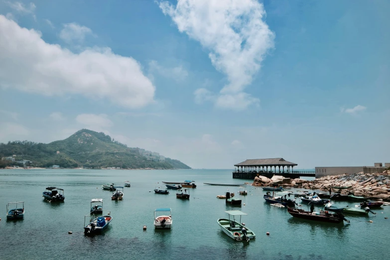 a number of small boats in a body of water, by Elsa Bleda, pexels contest winner, mingei, hong kong, clear blue skies, small port village, conde nast traveler photo