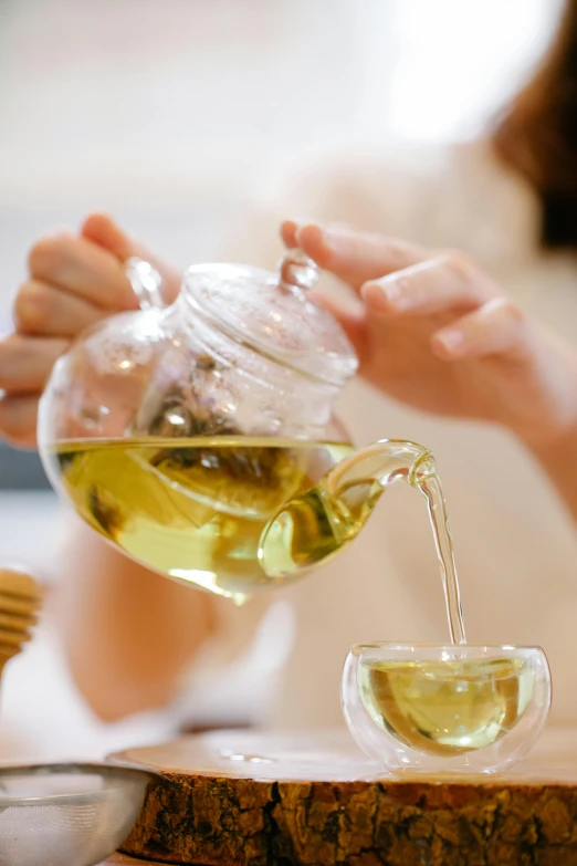 a woman pouring tea into a glass cup, by Elizabeth Durack, pexels, renaissance, olive oil, square, with a white, chinese