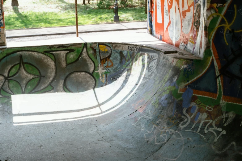 a man riding a skateboard up the side of a ramp, a picture, by Grillo Demo, unsplash, graffiti, green oozing pool pit, berlin park, bowl, exposed inner structure