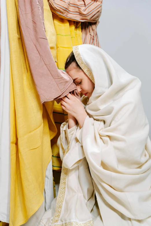 a woman is covering her face with a blanket, renaissance, religious robes, white and yellow scheme, jesus hugging a woman, profile image