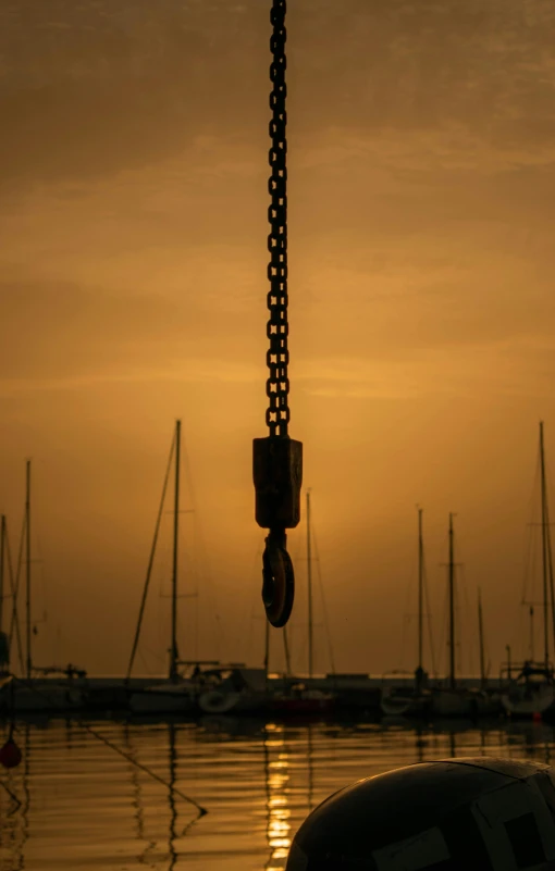 a car that is sitting in the water, by Peter Churcher, pexels contest winner, chains hanging from ceiling, iron giant at sunset, sailboat, ((chains))