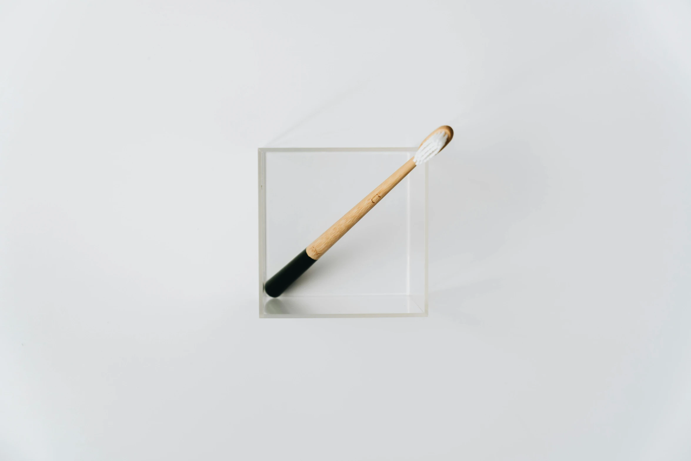 a brush in a clear box on a white surface, inspired by Inshō Dōmoto, minimalism, toothpaste refinery, medium: black pencil, bamboo, square