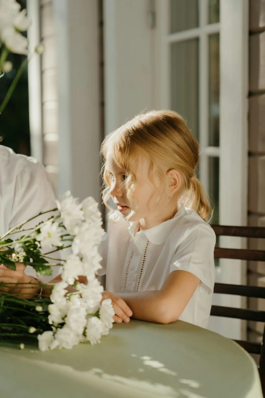 a man and a little girl sitting at a table, by Alice Mason, pexels contest winner, arts and crafts movement, white flowers, gif, bouquet, thinking