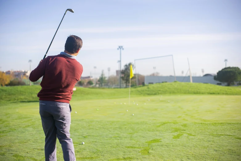 a man that is standing in the grass with a golf club, unsplash, happening, sportspalast amphitheatre, avatar image, various posed, back - shot