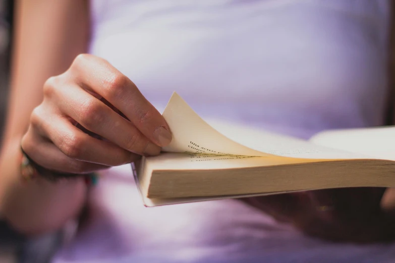 a close up of a person holding a book, by Carey Morris, pexels contest winner, fan favorite, quiet beauty, words, shot on 1 5 0 mm