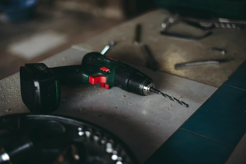 a black and red drill sitting on top of a counter, trending on pexels, workbench, background image, instagram picture, on a table