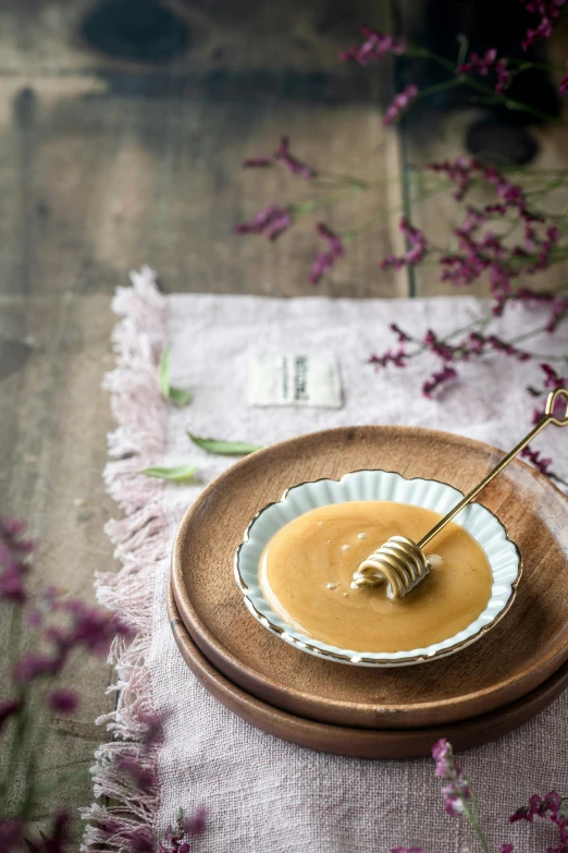 a close up of a plate of food on a table, a picture, inspired by Henriette Grindat, unsplash, renaissance, made of honey, soup, on wood, product display photograph