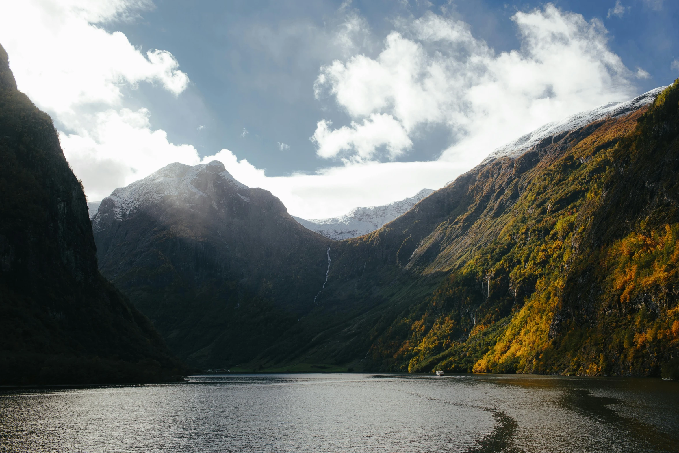 a body of water with mountains in the background, by Sebastian Spreng, pexels contest winner, hurufiyya, fjord, fall season, high light on the left, the middle of a valley