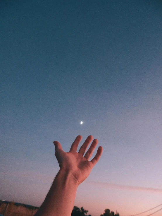 a person holding their hand up in the air, trending on unsplash, postminimalism, the moon is in the sky, ☁🌪🌙👩🏾, high light on the left, instagram story