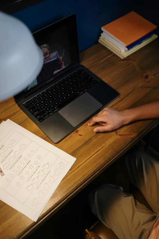 a person sitting at a desk with a laptop, woody\'s homework, lit from above, taken in 2 0 2 0, photograph credit: ap