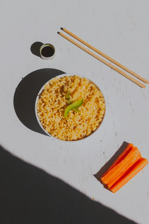 a bowl of noodles, carrots, and chopsticks on a table, unsplash, realism, detailed product image, sunny day time, neon orange, set against a white background