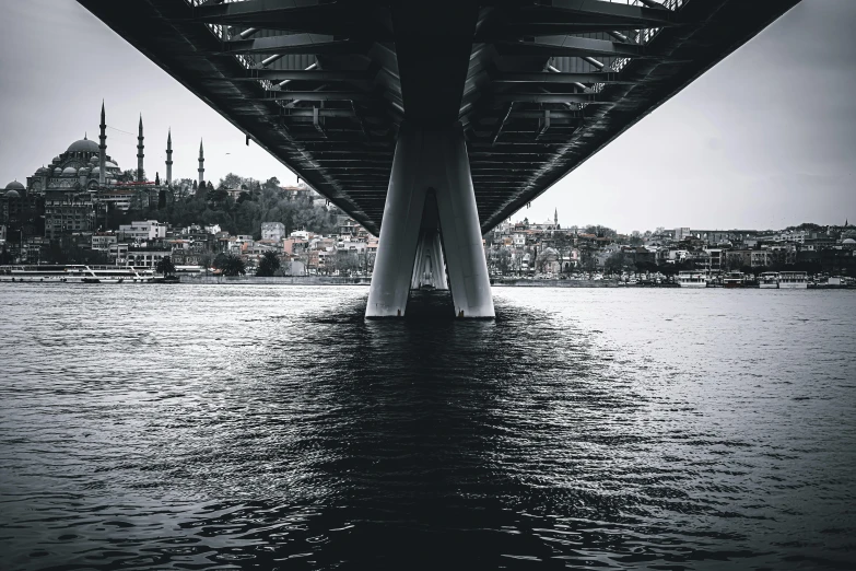 a black and white photo of a bridge over a body of water, by Ibrahim Kodra, pexels contest winner, hyperrealism, istanbul, view from the bottom, desaturated color, multiple stories