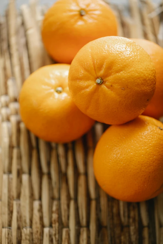 a pile of oranges sitting on top of a bamboo mat, a fruit basket, zoomed in, close up of iwakura lain, crisp image