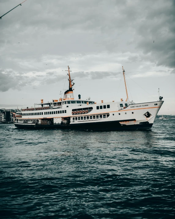 a large boat floating on top of a body of water, a colorized photo, pexels contest winner, istanbul, trending on vsco, non-binary, scandinavian