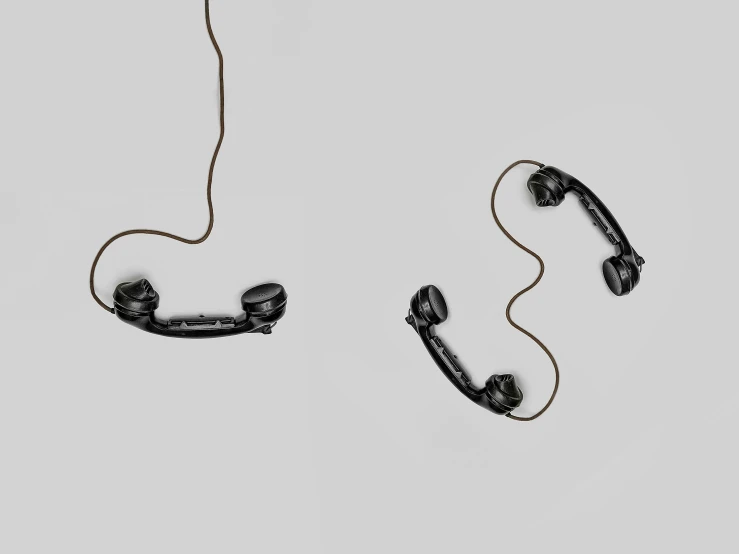 a couple of black phones sitting on top of a white surface, a digital rendering, by Jan Kupecký, conceptual art, attached to wires. dark, vintage - w 1 0 2 4, brown, fish hooks
