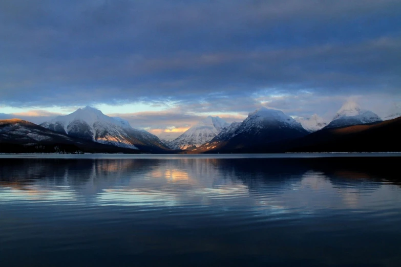 a body of water with mountains in the background, by Harald Giersing, pexels contest winner, hurufiyya, calm evening, cold colours, panoramic shot, fan favorite