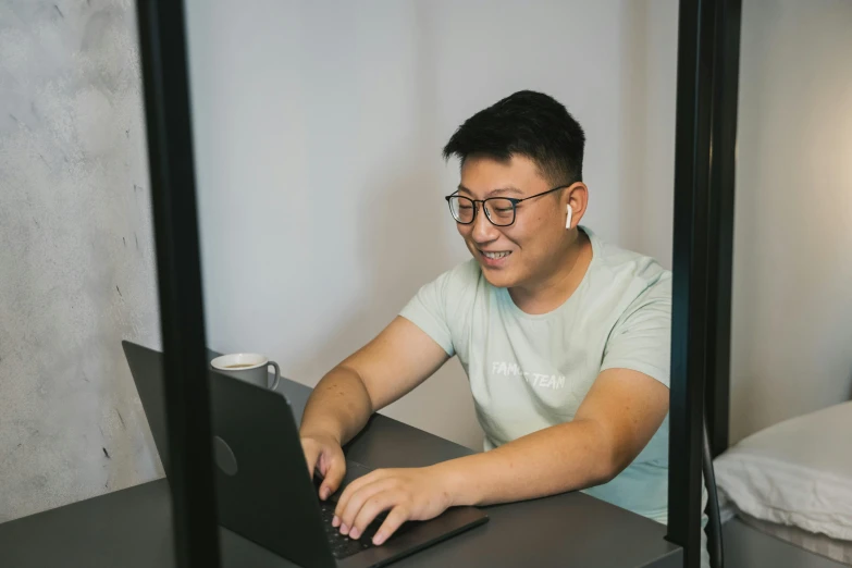 a man sitting at a desk using a laptop computer, inspired by Patrick Ching, pexels contest winner, smiling slightly, ruan jia and brom, profile image, no - text no - logo