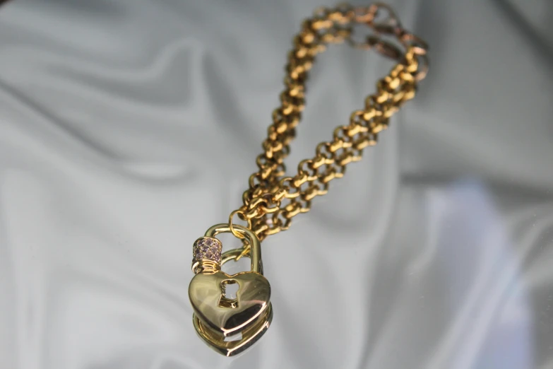 a close up of a chain with a heart on it, art nouveau, gold bracelet, padlocks, embedded with gemstones, listing image