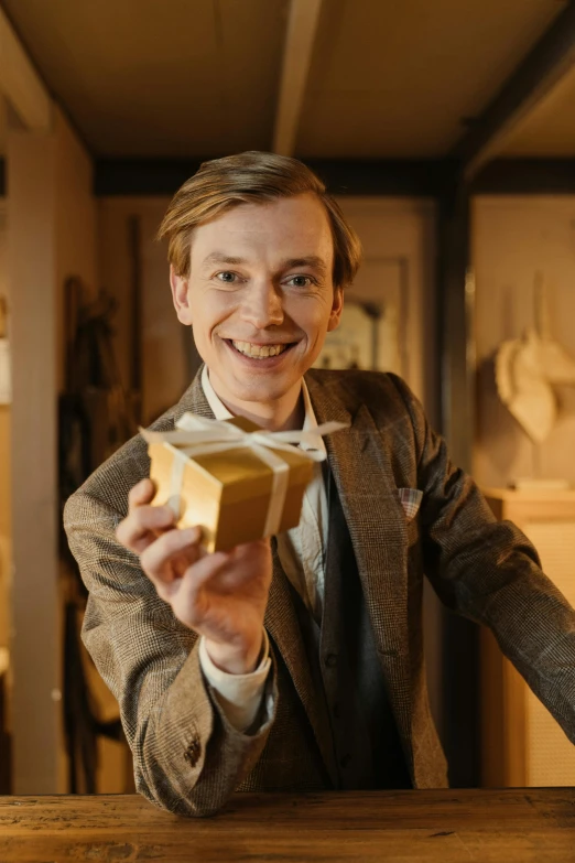a man in a suit holding a piece of bread, eleanor tomlinson, holding gift, wunderkammer, in a gold suit