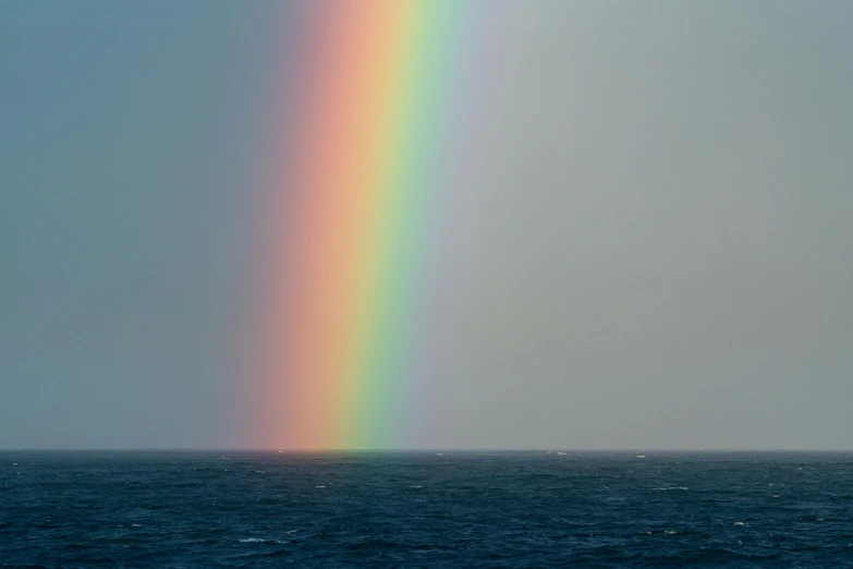 a rainbow in the sky over a body of water, an album cover, inspired by Jan Rustem, unsplash, romanticism, nadav kander, taken in the late 2010s, open ocean, dirk dzimirsky