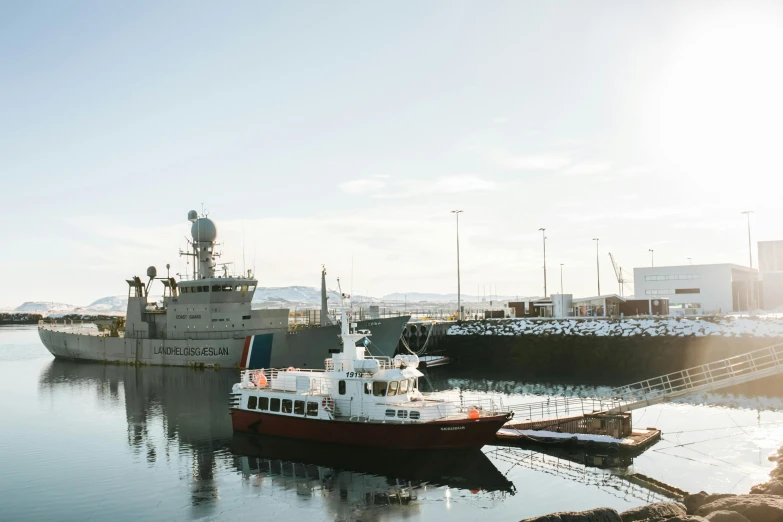 a red and white boat in a body of water, by karlkka, reykjavik, impeccable military composure, shipping docks, thumbnail