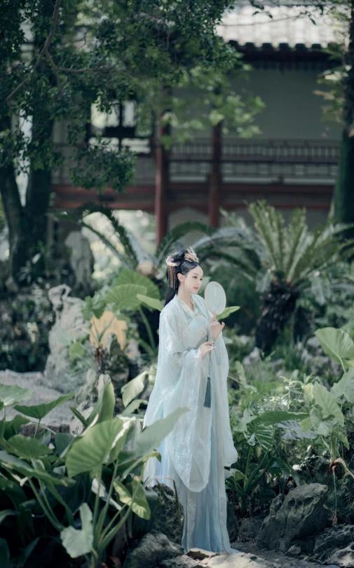 a woman standing in a garden holding a fan, inspired by Lan Ying, pexels contest winner, 15081959 21121991 01012000 4k, wearing ornate silk clothes, cinematic. by leng jun, panoramic view of girl
