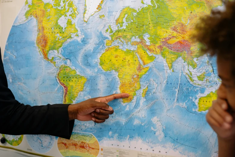 two people pointing at a map of the world, jemal shabazz, photographed for reuters, fan favorite, closeup - view