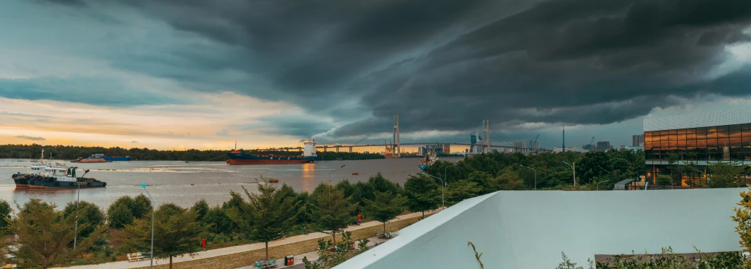 a view of a large body of water under a cloudy sky, a colorized photo, by Joze Ciuha, unsplash contest winner, rostov city, storm arriving, port scene background, humid evening