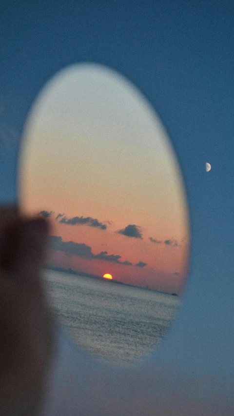 a reflection of a sunset in a mirror, pexels contest winner, photorealism, refracted moon on the ocean, magnifying glass, bali, slide show