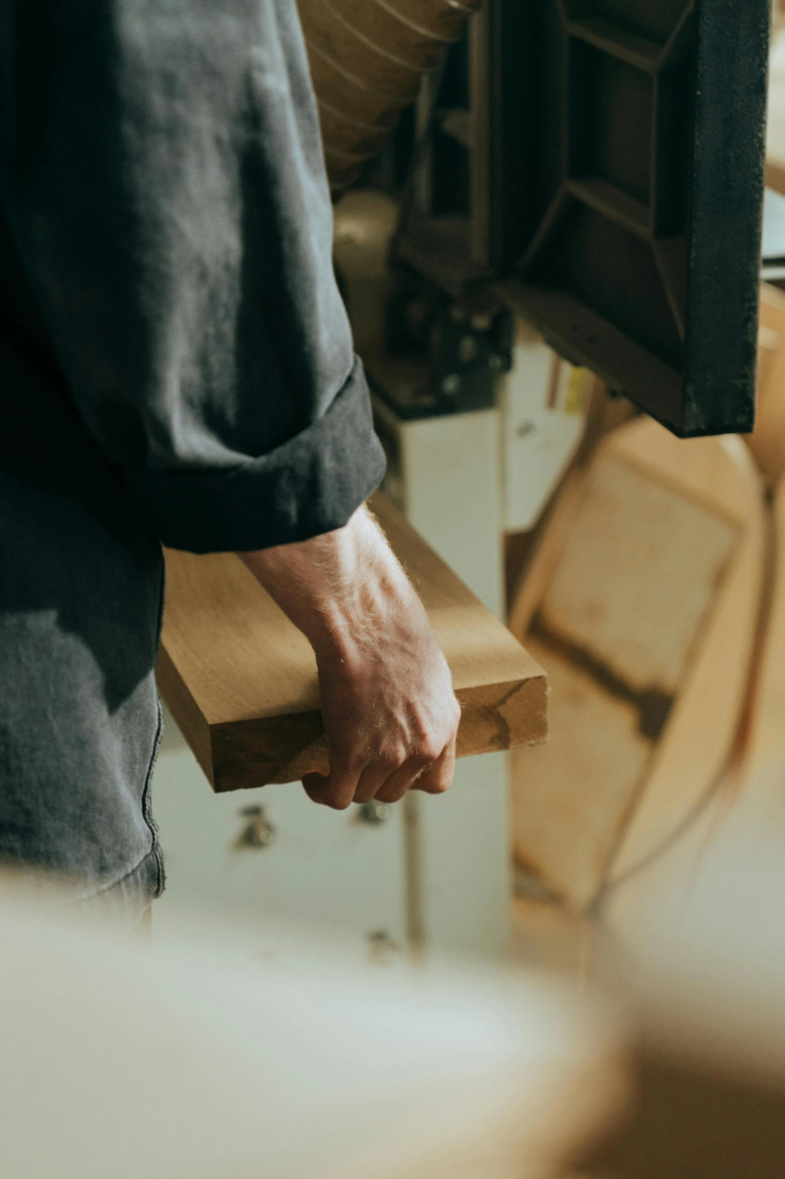 a man holding a piece of wood in his hands, pexels contest winner, arts and crafts movement, in a factory, crisp smooth clean lines, thumbnail, ignant