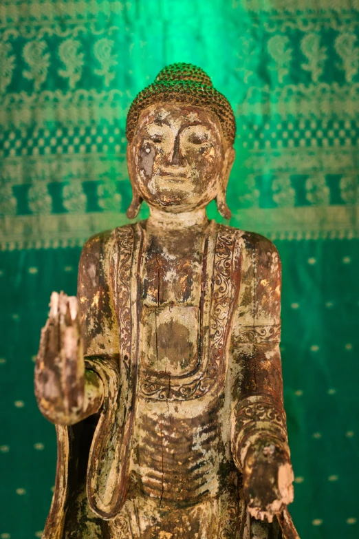 a statue of a buddha in front of a green background, preserved museum piece, ornate wood, slide show, bryan sola