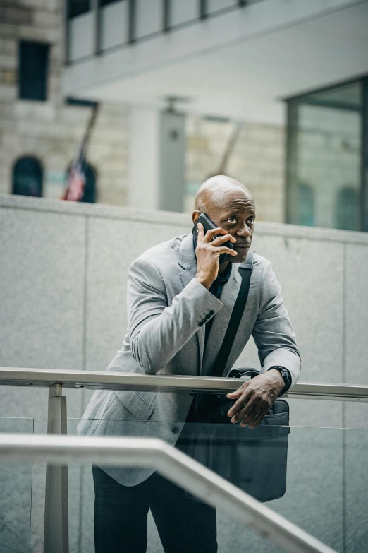 a man in a suit talking on a cell phone, a photo, inspired by Charles Alston, pexels contest winner, muscular bald man, waiting, shot from movie, promo material