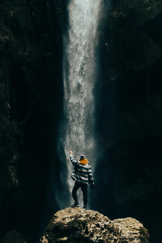 a person standing on a rock in front of a waterfall, by Andries Stock, unsplash contest winner, visual art, full body 8k, up there, coban, texture