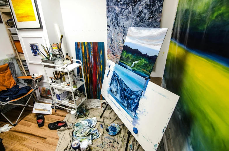 a room that has a bunch of paintings on the wall, a photorealistic painting, by Meredith Dillman, unsplash, process art, palette knife and brush strokes, blue and green colours, “ iron bark, dramatic scenery