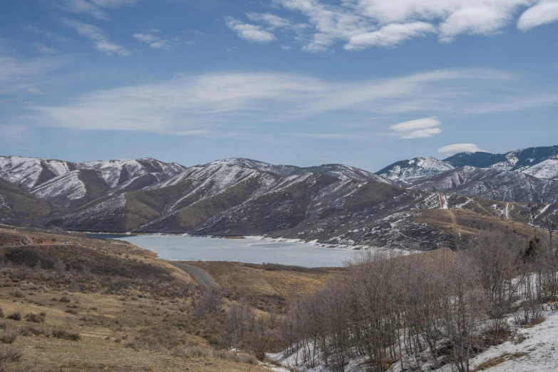 a man riding skis down a snow covered slope, by Ryan Pancoast, unsplash contest winner, a lake between mountains, spring winter nature melted snow, utah, panorama view